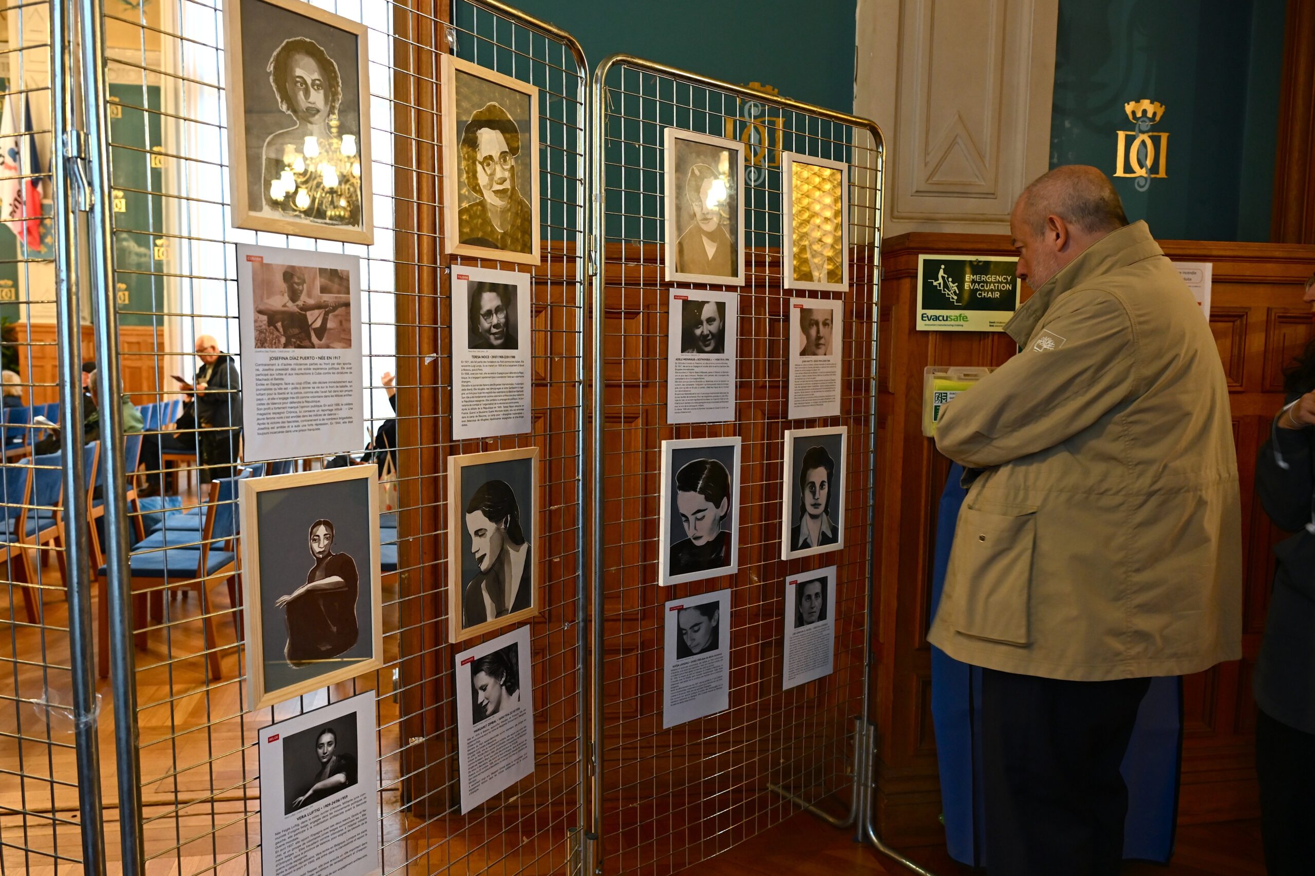 Le délégué à la culture de l'Ambassade d'Espagne regarde les portraits des femmes étrangères engagées en Espagne